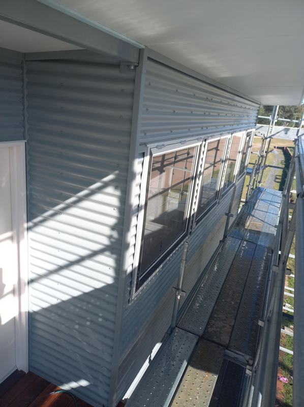 New metal wall cladding along an upper walkway