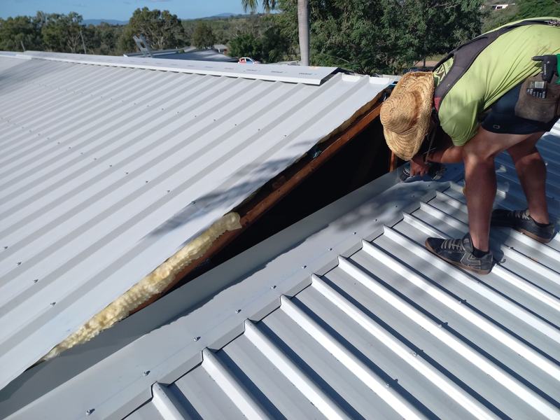 A Jaymac roofer fixing new metal sheets during a reroof